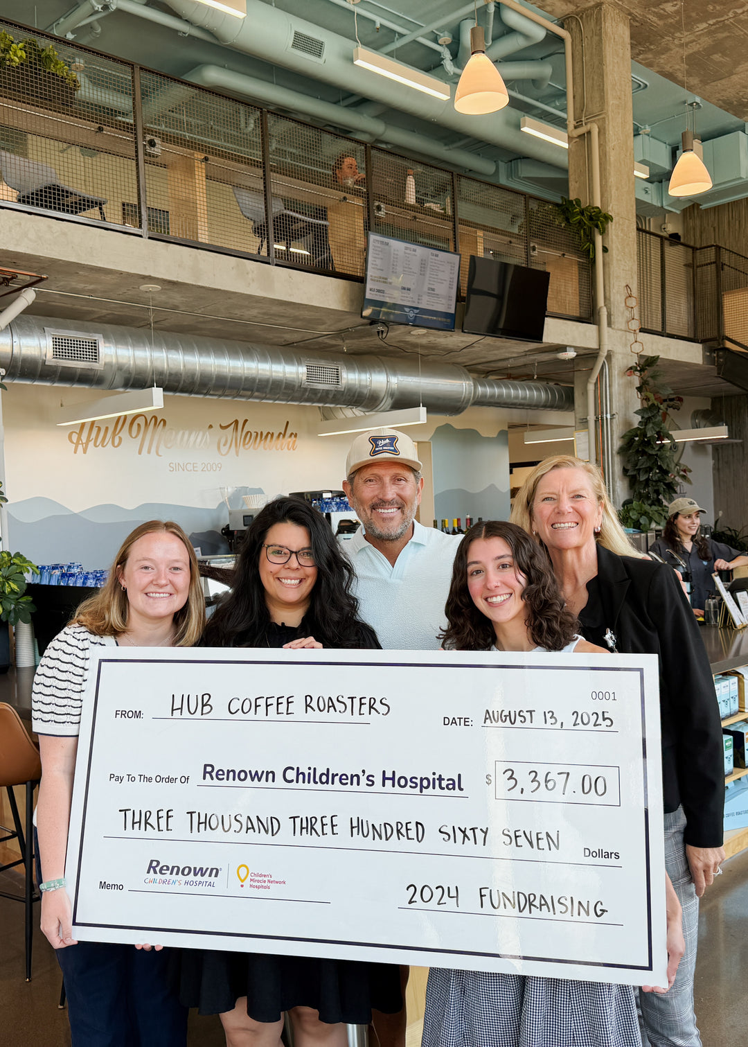 Group of people holding a large check for Hub Coffee Roasters to Renown Children's Hospital.